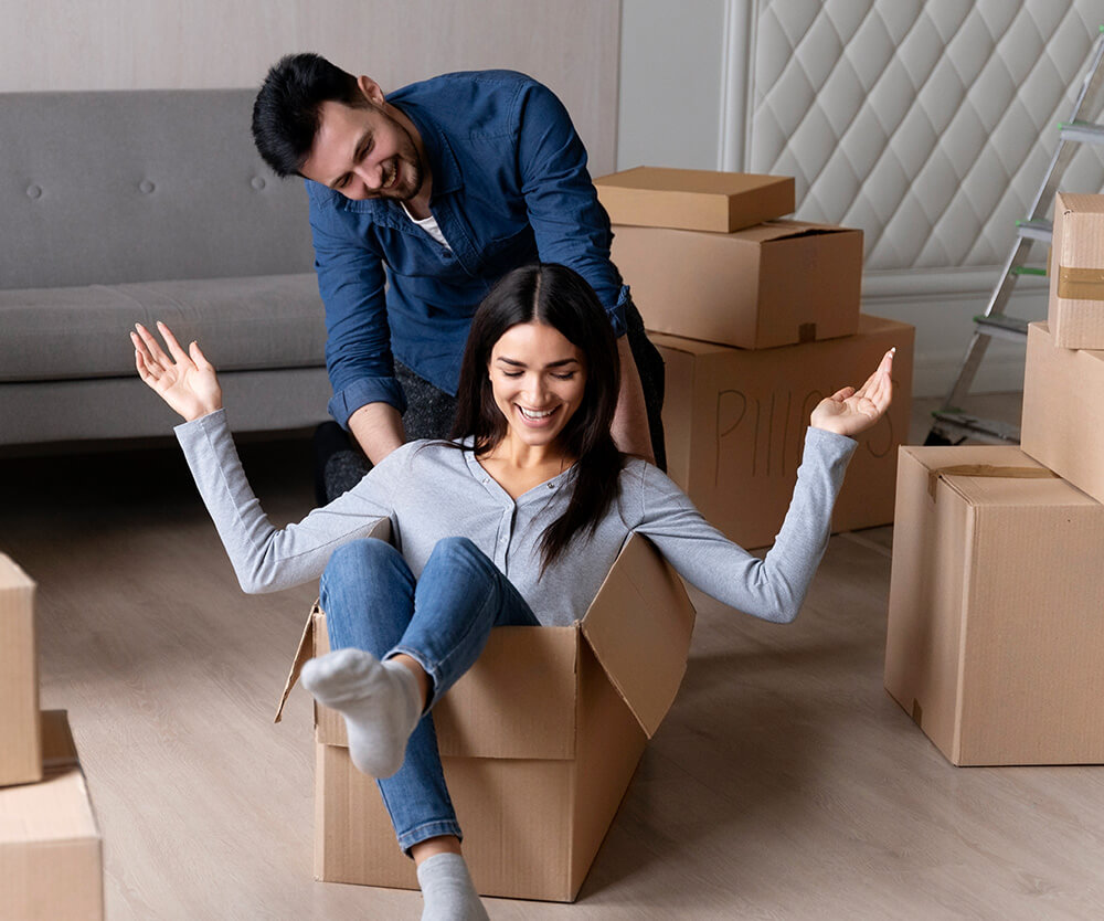 woman inside a cardboard box with her hands in the air